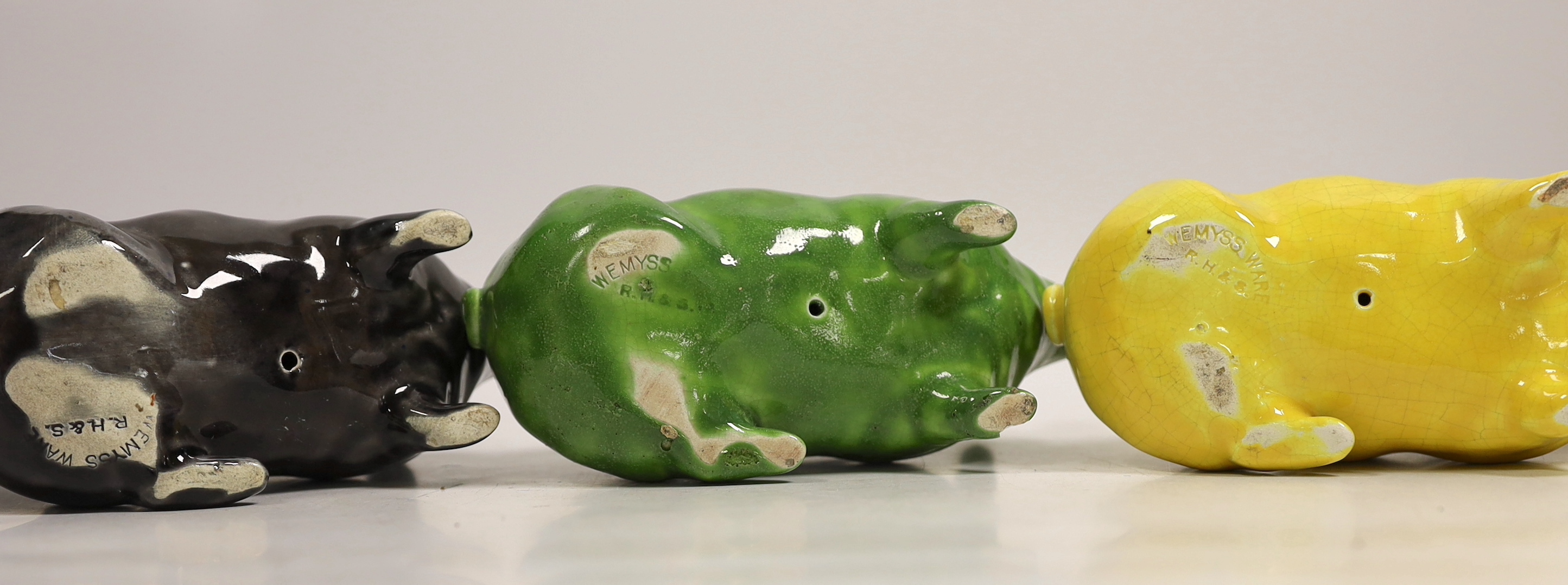 Three Wemyss ware pigs in green, yellow and black glazes, 15cm